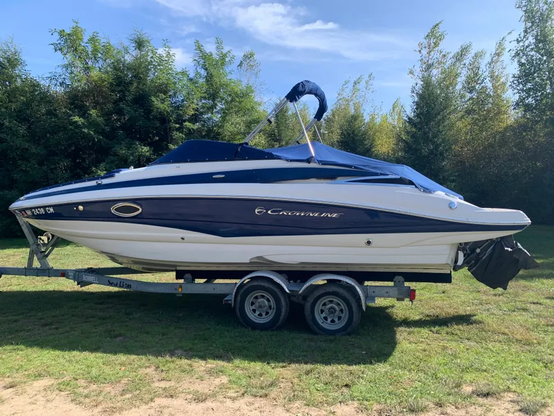 Slide: The Image of 2012 Crownline Eclipse E4 boat on a trailer in a grassy area. - 2