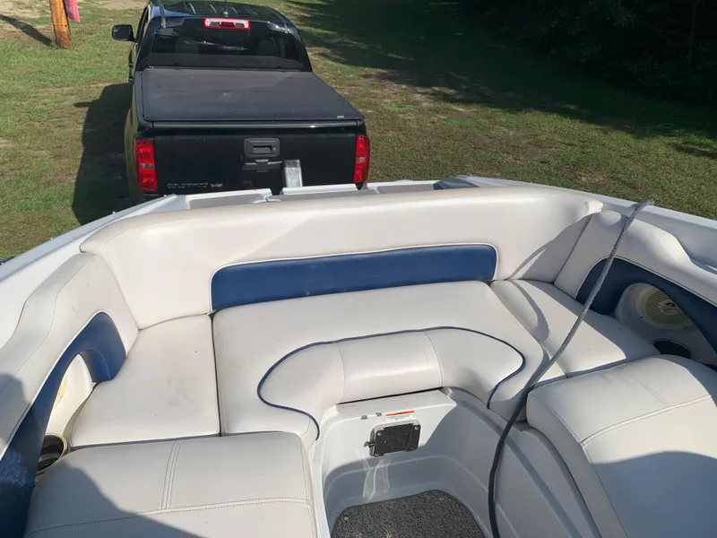 Slide: The Image of 2012 Crownline Eclipse E4 boat interior with white and blue seating, hitched to a black truck. - 25