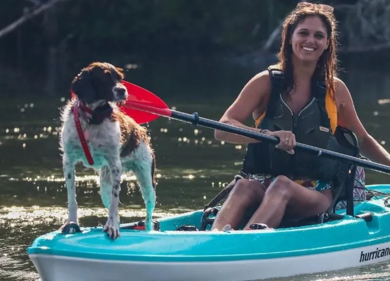Slide: The Image of Woman kayaking with dog on Hurricane Kayaks Osprey 120, 2023 model. - 2