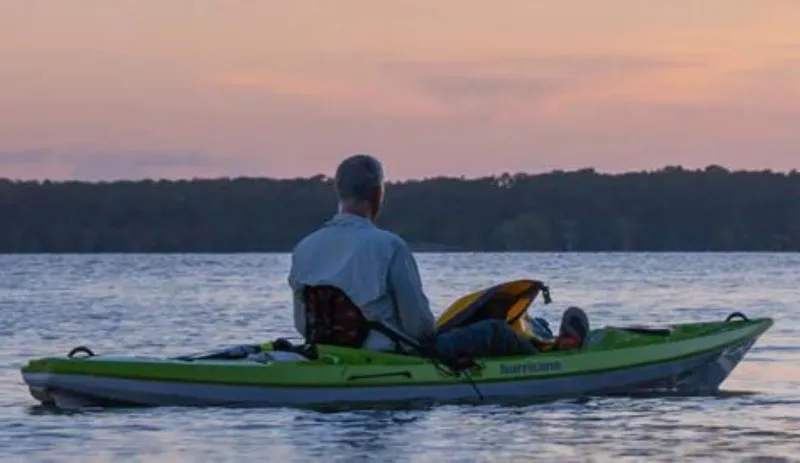 Slide: The Image of Man kayaking on a lake at sunset in a 2023 Hurricane Kayaks Skimmer 128. - 8