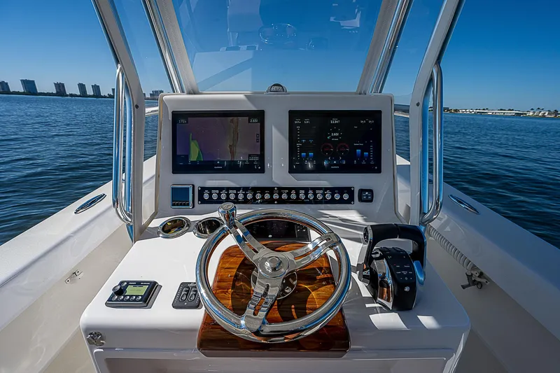 Slide: The Image of 2020 Birdsall 30 CC boat console with dual screens and steering wheel on open water. - 12