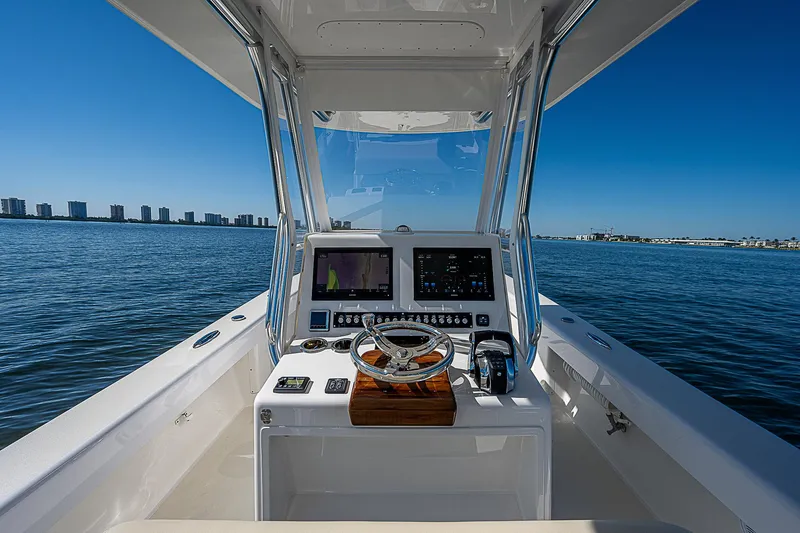 Slide: The Image of 2020 Birdsall 30 CC boat cockpit with steering wheel and navigation screens on open water. - 32
