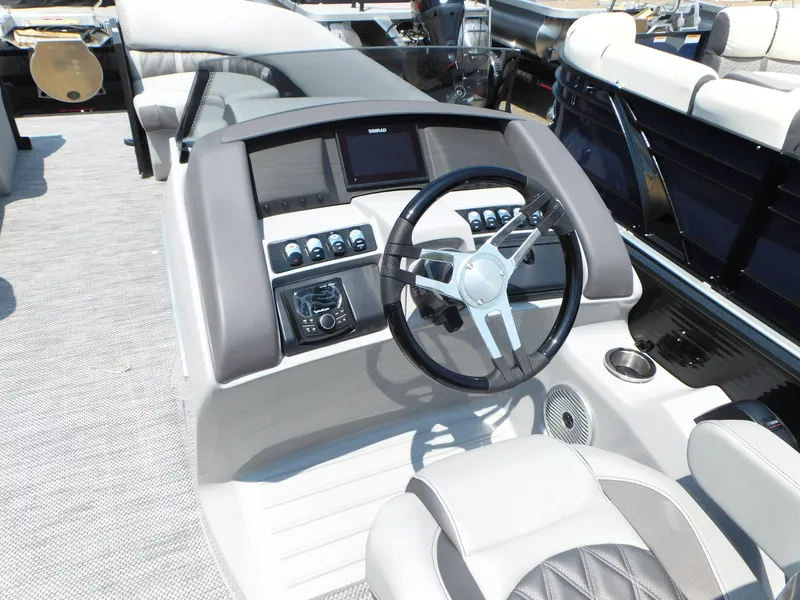 Slide: The Image of 2023 Bennington 24 LXSB boat helm with steering wheel and control panel. - 10
