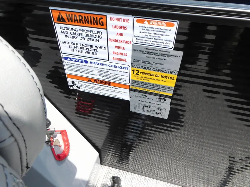 Slide: The Image of 2023 Bennington 24 LXSB safety and capacity warning labels on boat interior. - 11