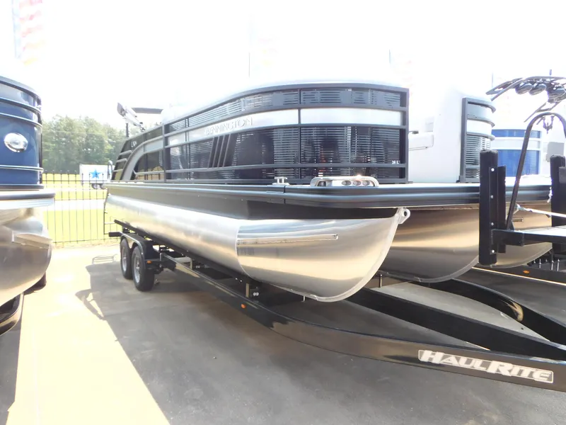 Slide: The Image of 2023 Bennington 24 LXSB pontoon boat on a trailer. - 2