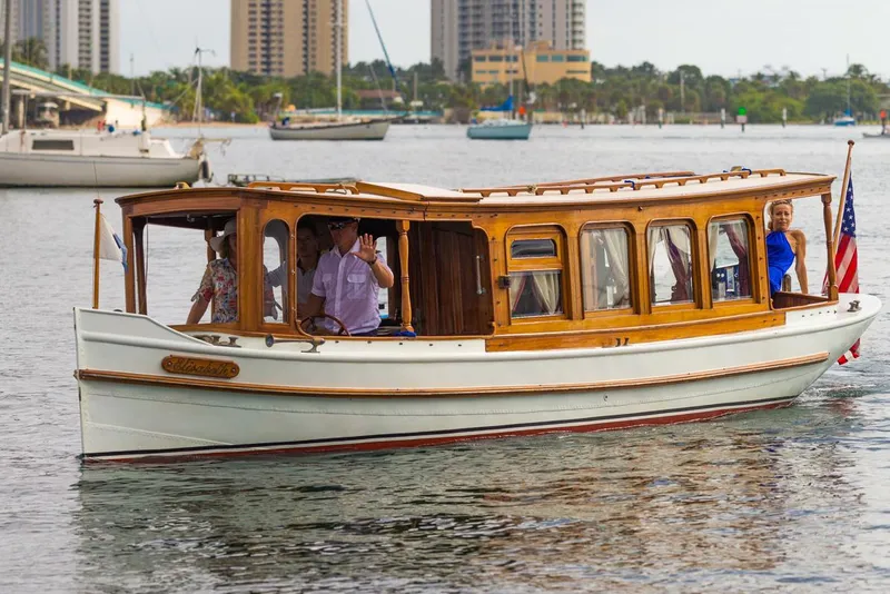 Slide: The Image of Classic 1910 Gentleman’s Commuter yacht cruising on a city waterfront with passengers. - 1