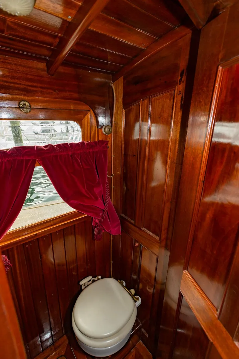Slide: The Image of 1910 Classic Gentleman’s Commuter yacht wooden interior with toilet and red curtains. - 12