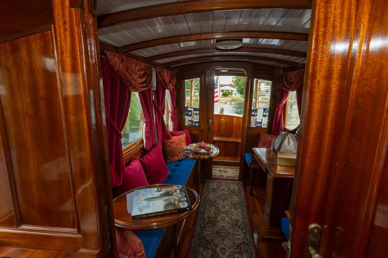 Slide: The Image of Luxurious interior of a 1910 Classic Gentleman’s Commuter yacht with wooden finishes and plush seating. - 13