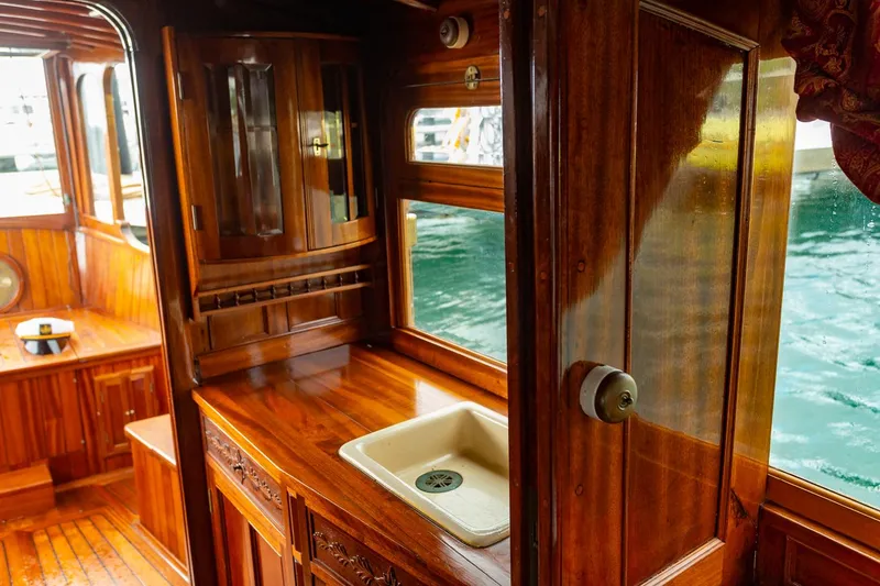 Slide: The Image of Interior of a 1910 Classic Gentleman’s Commuter yacht with polished wooden cabinetry. - 9