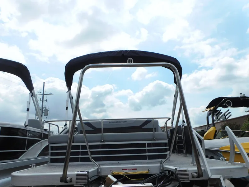 Slide: The Image of 2023 Bennington 22 SX Swingback pontoon boat under a cloudy sky. - 2