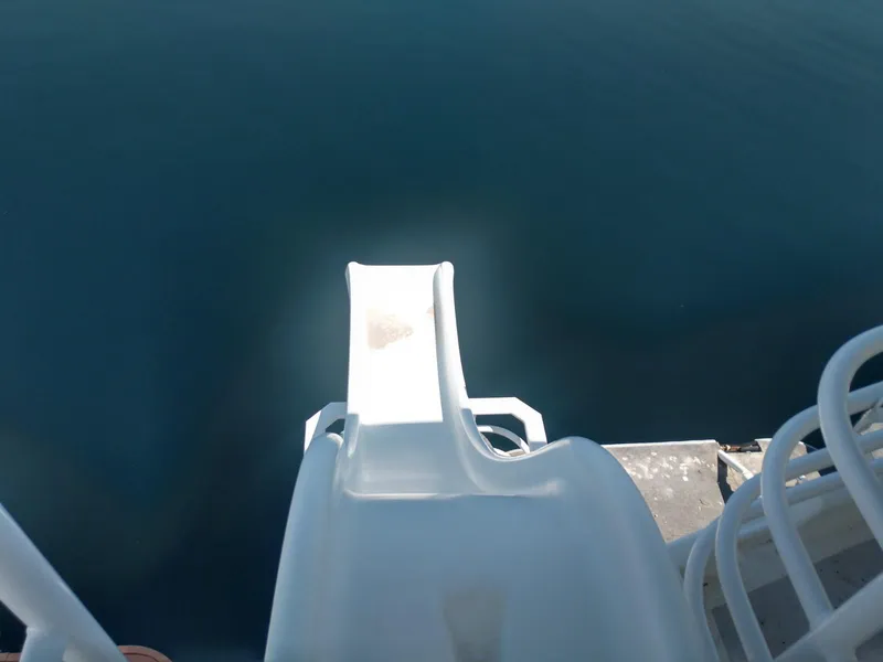 Slide: The Image of White slide on Twin Anchors Caspian share #9 houseboat, 2005 model, leading into calm water. - 34