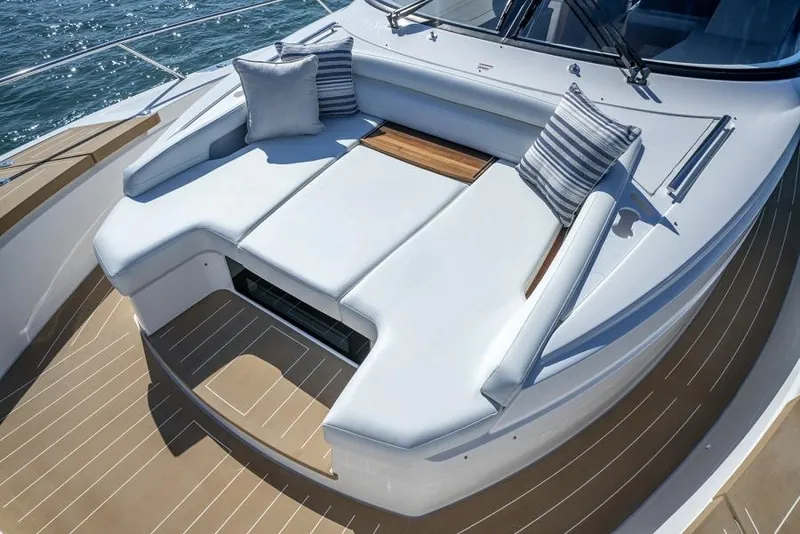 Slide: The Image of 2025 Tiara Yachts EX60 deck with cushioned seating and striped pillows. - 15