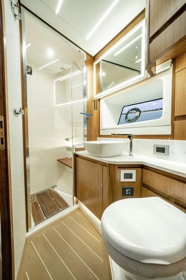 Slide: The Image of 2025 Tiara Yachts EX60 bathroom with modern fixtures and wooden accents. - 31
