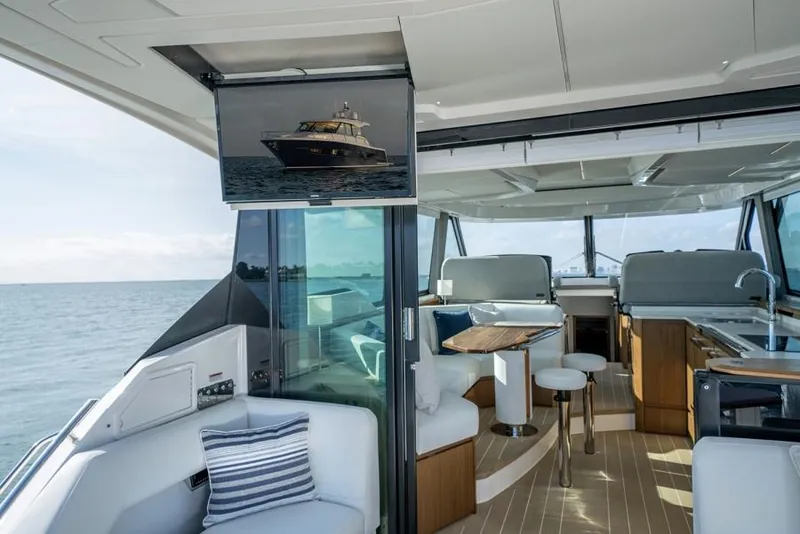Slide: The Image of Interior of 2025 Tiara Yachts EX60, featuring modern seating and ocean view. - 9