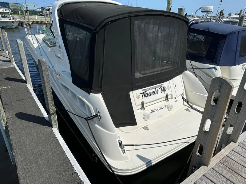 Slide: The Image of 2008 Sea Ray 330 Sundancer docked at a marina with black canvas cover. - 2