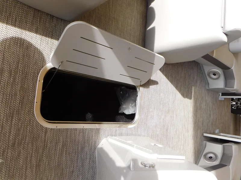 Slide: The Image of 2023 Bennington 22SX SWINGBACK boat interior storage compartment open. - 10