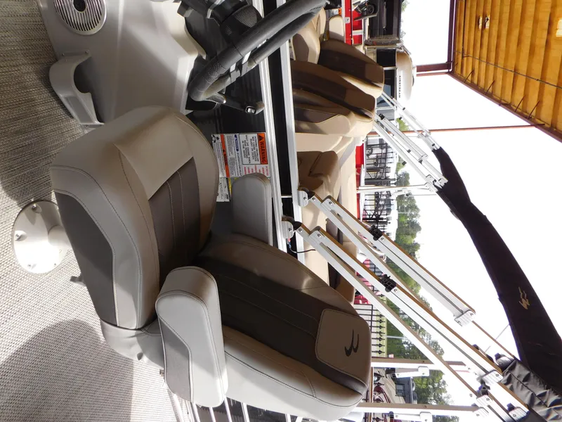 Slide: The Image of 2023 Bennington 22SX Swingback boat interior with plush seating and steering wheel. - 4