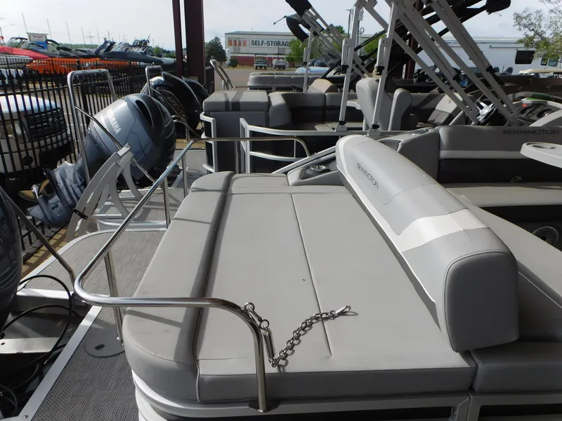 Slide: The Image of 2023 Bennington 22SX SWINGBACK pontoon boat with gray seating and metal railings. - 5