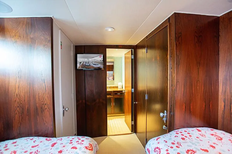 Slide: The Image of Twin beds in a cozy 1966 Burger Classic yacht cabin with floral bedding. - 28