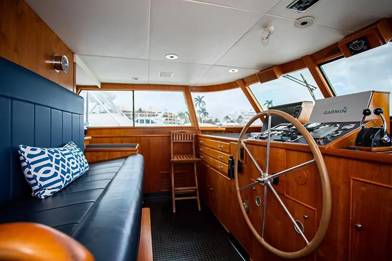 Slide: The Image of Interior of a 1966 Burger Classic yacht with wooden helm and blue seating. - 39