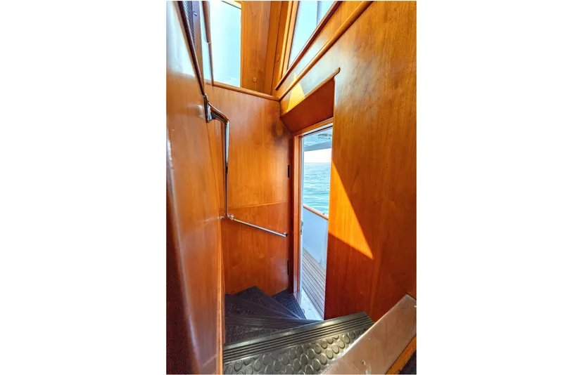 Slide: The Image of Wood-paneled stairway on a 1966 Burger Classic yacht, leading to an exterior deck with ocean view. - 41