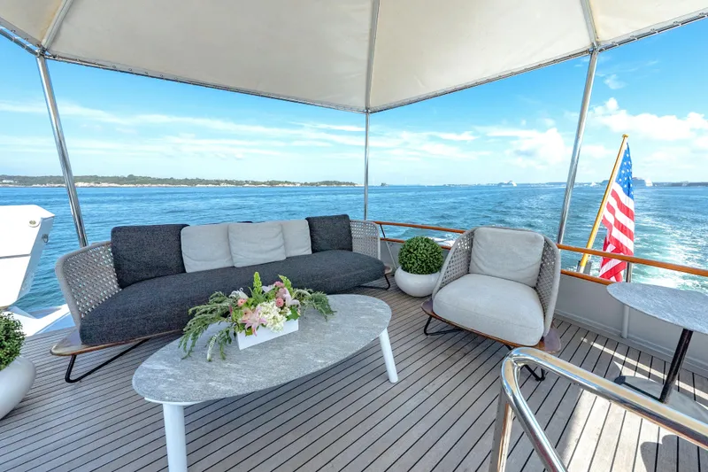 Slide: The Image of Luxurious 1966 Burger Classic yacht deck with elegant seating, ocean view, and American flag. - 48