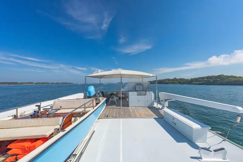 Slide: The Image of Classic 1966 Burger yacht deck with seating, canopy, and ocean view under clear blue sky. - 52