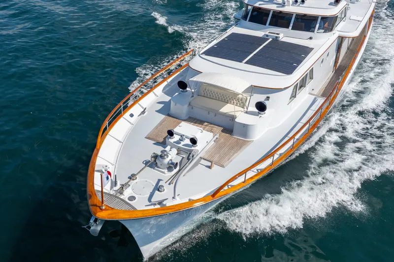 Slide: The Image of Classic 1966 Burger yacht cruising on open water, featuring elegant wooden accents and solar panels. - 54