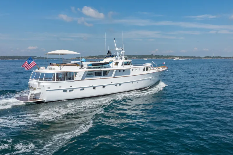 Slide: The Image of Classic 1966 Burger yacht cruising on open water under a clear blue sky. - 55
