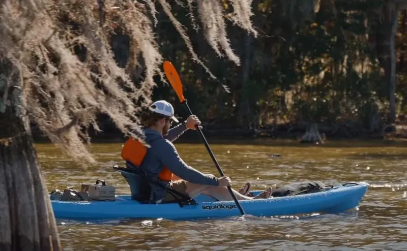 Slide: The Image of Man kayaking in a 2023 Liquidlogic Kiawah 10.5 on a calm river. - 5