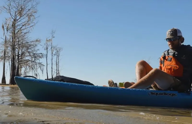Slide: The Image of Man kayaking in a 2023 Liquidlogic Kiawah 10.5 on a calm lake. - 9
