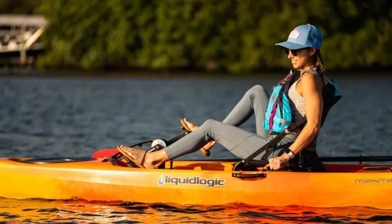 Slide: The Image of Woman kayaking on Liquidlogic Manta Ray Propel 12, 2023 model, in serene lake. - 6