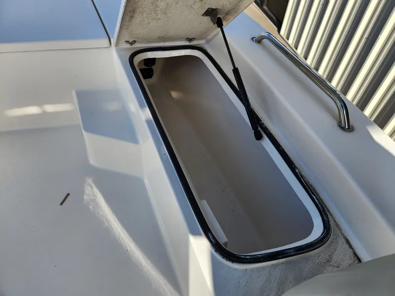 Slide: The Image of 2023 May-Craft 220 Bay boat storage compartment with open lid and hydraulic support. - 10