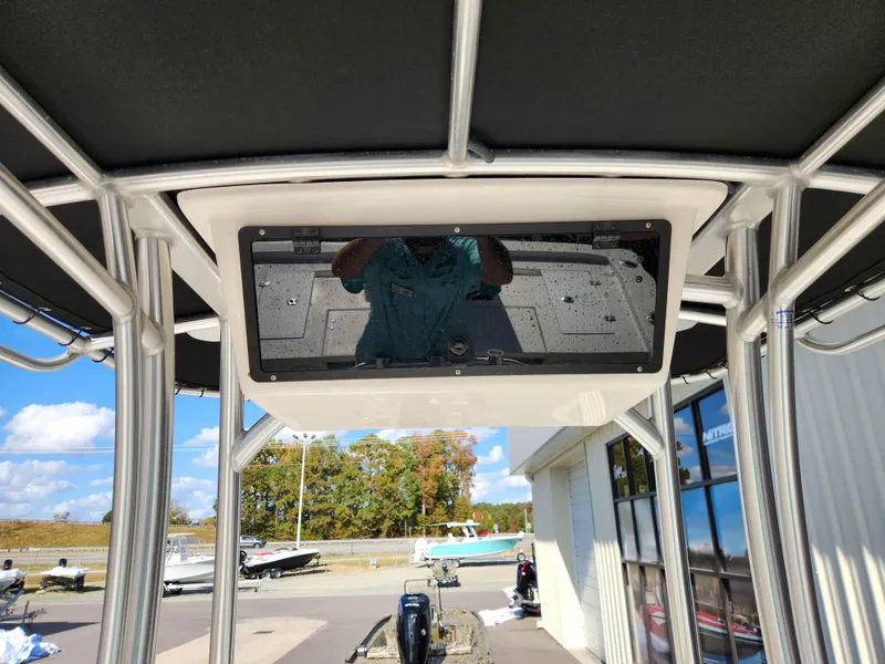 Slide: The Image of 2023 May-Craft 220 Bay boat console with reflection, outdoor setting. - 20