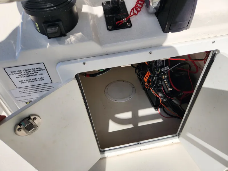 Slide: The Image of Open compartment on 2023 May-Craft 220 Bay boat showing wiring and equipment. - 21
