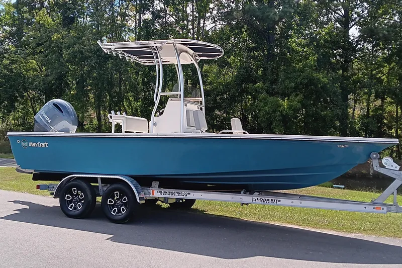 Slide: The Image of 2023 May-Craft 220 Bay boat on trailer, parked outdoors with trees in background. - 3