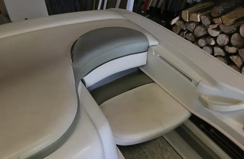 Slide: The Image of 2005 Sea Ray 200 Sport boat interior seating area with white and gray upholstery. - 11