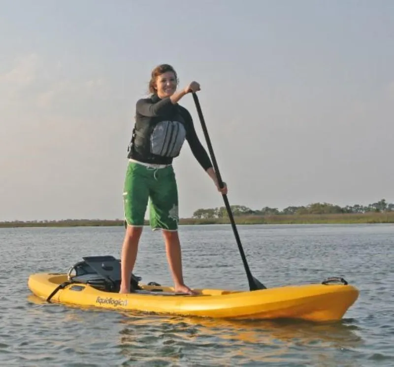 Slide: The Image of Person paddleboarding on a 2023 Liquidlogic Versa Board in calm waters. - 9
