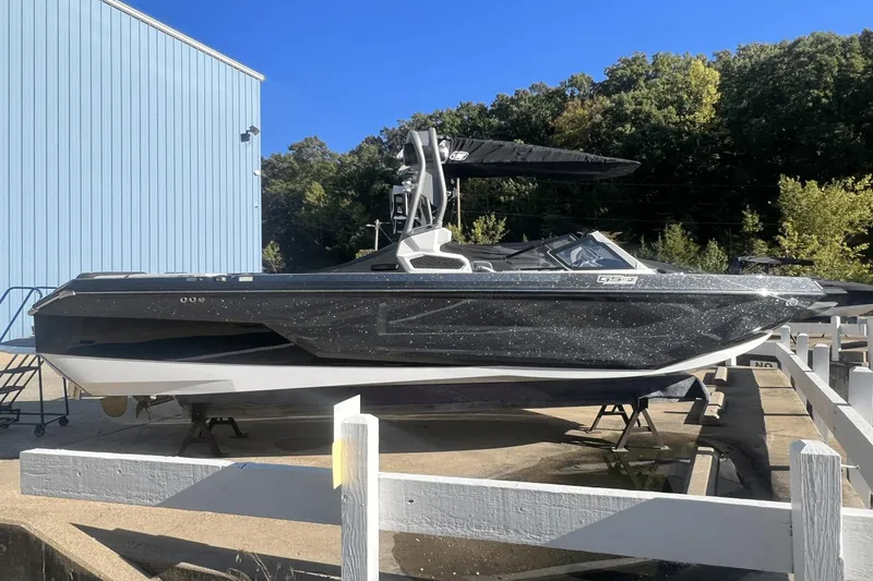 Slide: The Image of 2024 Nautique Super Air Nautique GS24 boat displayed outdoors, side view. - 0