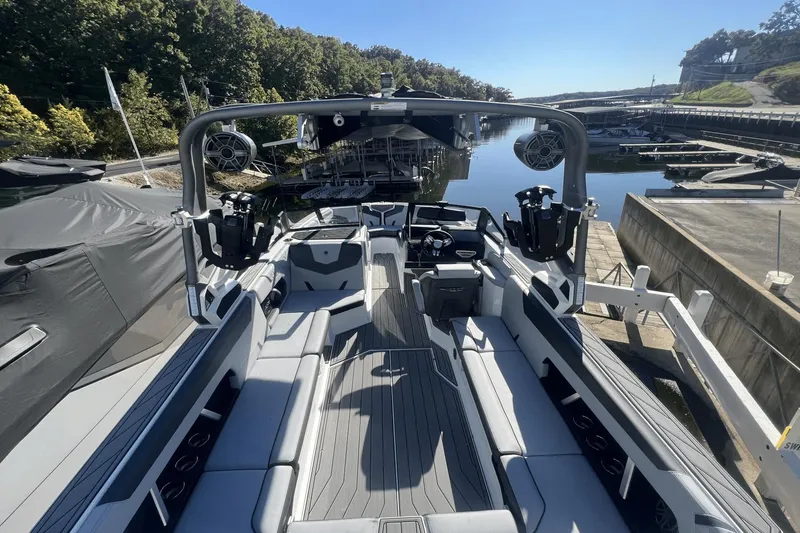 Slide: The Image of 2024 Nautique Super Air Nautique GS24 boat interior at a marina dock. - 1