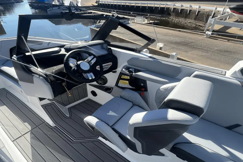 Slide: The Image of 2024 Nautique Super Air Nautique GS24 boat interior with modern steering and seating. - 2