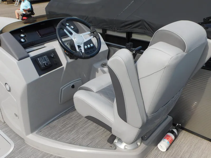 Slide: The Image of 2023 Bennington 23LFB boat helm with gray captain's chair and steering wheel. - 6