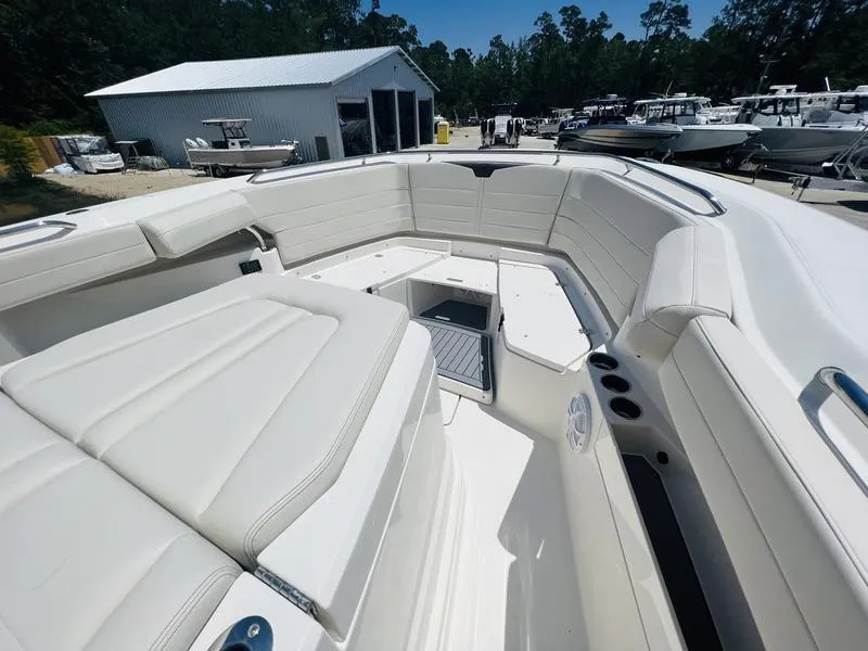 Slide: The Image of 2024 Sailfish 360 CC boat interior with white cushioned seating and storage compartments. - 10