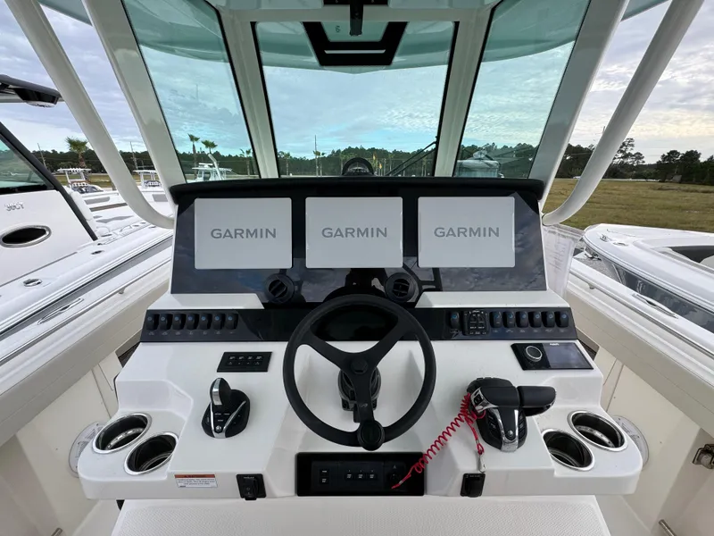 Slide: The Image of 2024 Sailfish 360 CC boat dashboard with Garmin displays and steering wheel. - 15