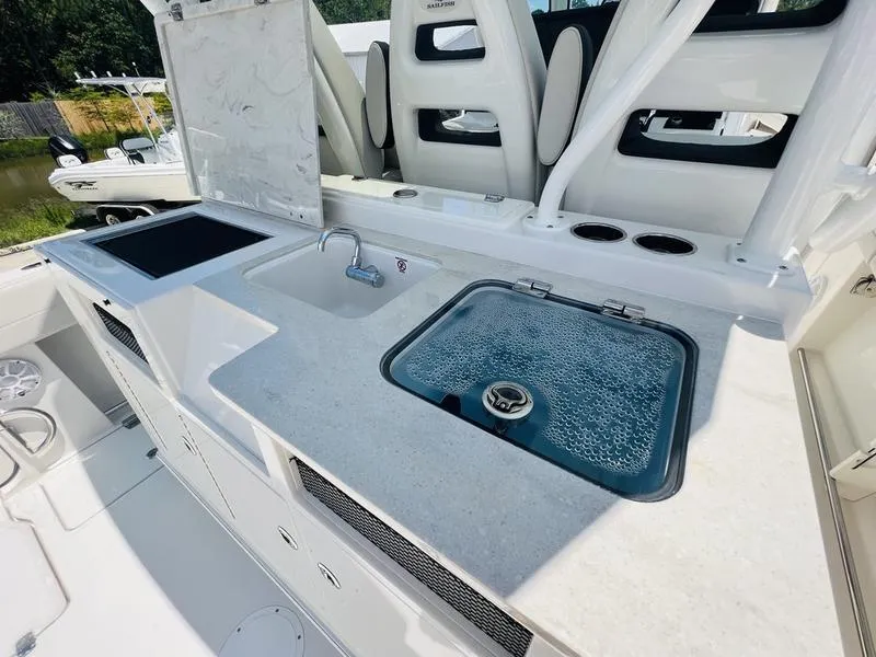 Slide: The Image of 2024 Sailfish 360 CC boat interior with sink, stove, and seating area. - 21