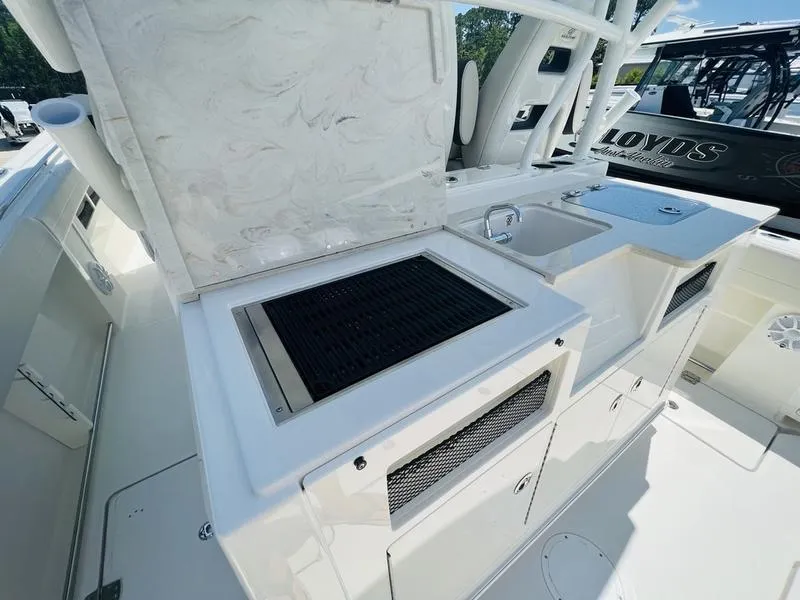 Slide: The Image of Outdoor kitchen area on 2024 Sailfish 360 CC boat with grill and sink. - 22