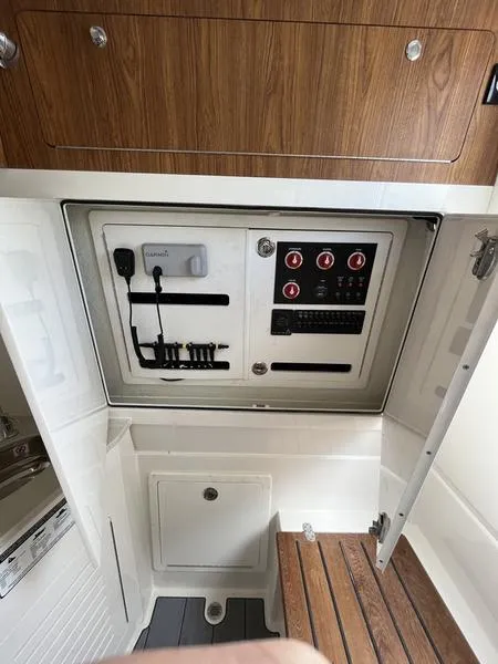 Slide: The Image of Control panel of 2024 Sailfish 360 CC boat with wooden accents and storage compartments. - 27