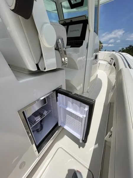 Slide: The Image of 2024 Sailfish 360 CC boat interior with open mini fridge. - 43