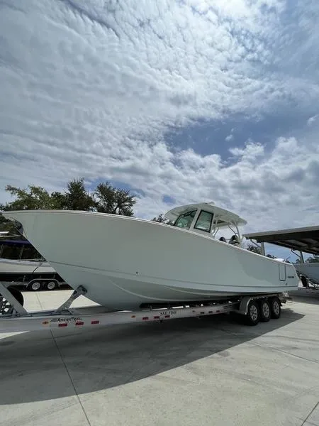 Slide: The Image of 2024 Sailfish 360 CC boat on a trailer under a cloudy sky. - 56