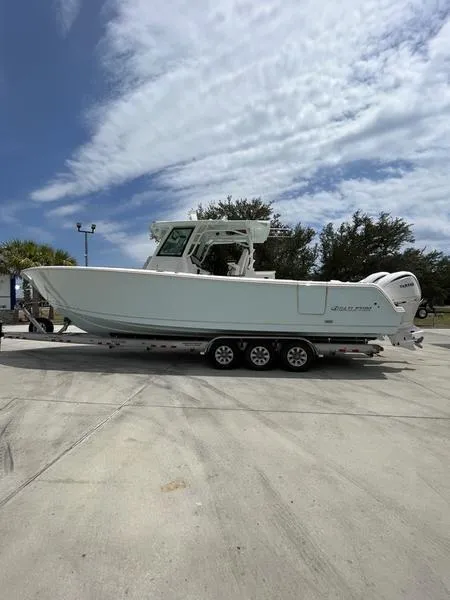 Slide: The Image of 2024 Sailfish 360 CC boat on a trailer under a partly cloudy sky. - 57